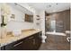 Modern bathroom with granite countertop, dark cabinets and tiled shower with a glass door at 1080 Peachtree Ne St # 2006, Atlanta, GA 30309