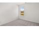 Minimalist bedroom with neutral carpet, an ample window, and crisp white walls, creating a serene atmosphere at 1891 Lacebark Elm Way, Lawrenceville, GA 30045