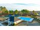 Aerial view of a community pool and tennis courts surrounded by mature trees at 1891 Lacebark Elm Way, Lawrenceville, GA 30045