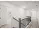 Bright hallway featuring carpeted floors and a wooden and wrought iron railing at 1891 Lacebark Elm Way, Lawrenceville, GA 30045