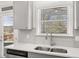 Close-up of a kitchen sink and stainless steel faucet, with view of landscaped yard at 1891 Lacebark Elm Way, Lawrenceville, GA 30045