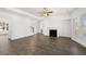 Spacious living room features hardwood floors, a ceiling fan, an electric fireplace, and large windows at 1891 Lacebark Elm Way, Lawrenceville, GA 30045