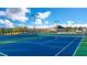 Well-maintained community tennis courts with modern lighting, surrounded by green landscaping at 1891 Lacebark Elm Way, Lawrenceville, GA 30045