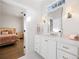 Bright bathroom features a white vanity with marble countertop and decorative mirror, adjacent to bedroom at 3063 Peachtree Ne Dr, Atlanta, GA 30305