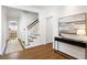 Bright hallway featuring hardwood floors, a modern console table, staircase, and kitchen view at 3063 Peachtree Ne Dr, Atlanta, GA 30305