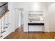 Bright hallway featuring hardwood floors, a modern console table, and staircase with wood handrail at 3063 Peachtree Ne Dr, Atlanta, GA 30305