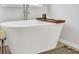 Close up view of a white soaking tub next to a small table with modern décor and a natural rug at 412 Barley Lot 86 Ct, Covington, GA 30014