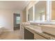 Modern bathroom featuring dual sinks with granite countertops, tile flooring, and illuminated mirrors at 412 Barley Lot 86 Ct, Covington, GA 30014