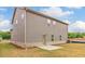 Backyard view of a two-story home with gray siding, brick foundation, and a small patio at 412 Barley Lot 86 Ct, Covington, GA 30014