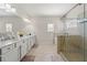 Bright bathroom featuring a double vanity, a glass-enclosed shower, and a soaking tub at 310 Nw Brightfield Dr, Loganville, GA 30052