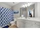 Bright bathroom featuring a vanity with a large mirror and a shower with a patterned curtain at 310 Nw Brightfield Dr, Loganville, GA 30052