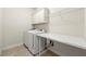 Functional laundry room equipped with washer, dryer, built-in cabinets and folding counter at 310 Nw Brightfield Dr, Loganville, GA 30052
