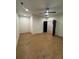 A bright bedroom features neutral walls, a ceiling fan, hardwood floors, and a dark door leading to another room at 110 Chiswick Cir # 40, Alpharetta, GA 30009