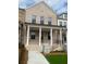 Charming two-story townhome boasts a light brick facade, covered porch, and well-manicured lawn at 110 Chiswick Cir # 40, Alpharetta, GA 30009