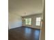 Neutral living room with hardwood floors, multiple windows, and modern lighting fixtures at 110 Chiswick Cir # 40, Alpharetta, GA 30009