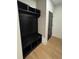 A mudroom featuring a built-in bench with storage and a black door, next to light hardwood floors at 110 Chiswick Cir # 40, Alpharetta, GA 30009