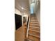 Wooden staircase with metal railings, adjacent to a doorway with a black door and wood floors at 110 Chiswick Cir # 40, Alpharetta, GA 30009