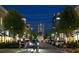 Street view of Avalon community showing parked cars and pedestrians walking at dusk at 110 Chiswick Cir # 40, Alpharetta, GA 30009