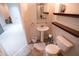 This bathroom features a pedestal sink, toilet, wooden shelves, and tiled floor at 849 Kirsten Jane Ct, Lawrenceville, GA 30045