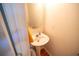 Cozy half-bath with a pedestal sink, oval mirror, and hardwood floors at 849 Kirsten Jane Ct, Lawrenceville, GA 30045