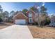 Inviting two-story brick home features a double garage and lush front yard landscaping at 849 Kirsten Jane Ct, Lawrenceville, GA 30045