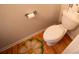 Compact half bathroom featuring a toilet, wood floors and a decorative flower mat at 849 Kirsten Jane Ct, Lawrenceville, GA 30045