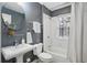 This main bathroom features a pedestal sink, grey walls, round mirror, and shower and bath at 272 14Th Ne St # 18, Atlanta, GA 30309