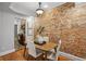 Cozy dining room featuring exposed brick wall and hardwood floors next to kitchen at 272 14Th Ne St # 18, Atlanta, GA 30309