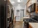 Functional kitchen with black appliances, tile countertops, and view into hallway at 272 14Th Ne St # 18, Atlanta, GA 30309