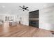 Open-concept living room features a fireplace, built-in shelves, and a view of the modern kitchen at 3474 Dryden Se Ln, Vinings, GA 30339