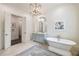 Elegant bathroom with a freestanding tub, blue vanity, arched mirror and access to the walk-in closet at 675 W Paces Ferry Nw Rd, Atlanta, GA 30327