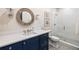 Stylish bathroom with a navy blue vanity, round mirror, and a glass-enclosed shower at 675 W Paces Ferry Nw Rd, Atlanta, GA 30327