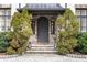 Stunning stone front door with a stately gray door, flanked by green shrubbery at 675 W Paces Ferry Nw Rd, Atlanta, GA 30327