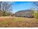 A view of the expansive backyard area that features a manicured lawn and mature trees at 6884 Robinson St, Lithonia, GA 30058