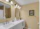 Bright bathroom featuring a double sink vanity with modern fixtures and herringbone pattern cabinet doors at 6884 Robinson St, Lithonia, GA 30058