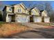 Townhomes showcase a modern exterior with neutral siding, white trim, and attached one-car garages at 6884 Robinson St, Lithonia, GA 30058