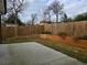 Fenced backyard featuring a concrete patio, lush green grass, and a wooden retaining wall at 180 S Alexander St, Buford, GA 30518