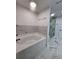 Bathroom featuring a soaking tub with modern marble-look tile and glass shower at 180 S Alexander St, Buford, GA 30518