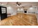 An open living room featuring hardwood flooring, a fireplace, and multiple ceiling fans at 180 S Alexander St, Buford, GA 30518