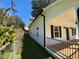 Side view of a white home with black shutters, showcasing the porch and well-maintained yard at 180 S Alexander St, Buford, GA 30518