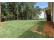 Expansive backyard featuring a lush lawn surrounded by mature trees, offering privacy and a natural setting at 313 Canoe Pl, Villa Rica, GA 30180