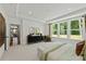 Bedroom with a large window, tray ceiling, stylish furnishings, and an ensuite door at 313 Canoe Pl, Villa Rica, GA 30180