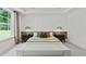 Spacious bedroom with a large window, tray ceiling, paneling, and stylish furnishings at 313 Canoe Pl, Villa Rica, GA 30180