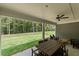 Covered patio with dining table, ceiling fan, and view of the expansive lawn and lush trees at 313 Canoe Pl, Villa Rica, GA 30180