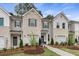 Charming townhomes featuring brick and siding exteriors, two-car garages, and professionally landscaped front yards at 308 Navigator Ln, Mcdonough, GA 30253