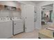 Well-lit laundry room with a washer, dryer, wire shelving, and a decorative laundry sign at 308 Navigator Ln, Mcdonough, GA 30253