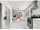 Modern kitchen with stainless steel appliances, marble floors, white cabinetry and adjacent dining room at 428 Sycamore Dr, Decatur, GA 30030