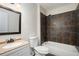 Modern bathroom featuring a vanity with a dark framed mirror, toilet, and tiled bathtub at 4962 Preswick Ne Ct, Marietta, GA 30066