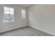 Neutral bedroom featuring two windows, carpet and base trim at 1236 Ainsworth Aly # 37, Sugar Hill, GA 30518