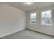 Neutral bedroom featuring two windows, carpet and base trim at 1236 Ainsworth Aly # 37, Sugar Hill, GA 30518